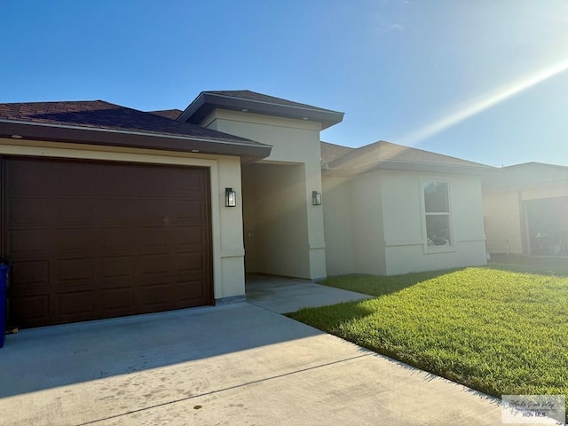 17134 Mandarin Ave, Harlingen, TX 78552 - view of front of home featuring concrete driveway, stucco siding, a front lawn, and a garage