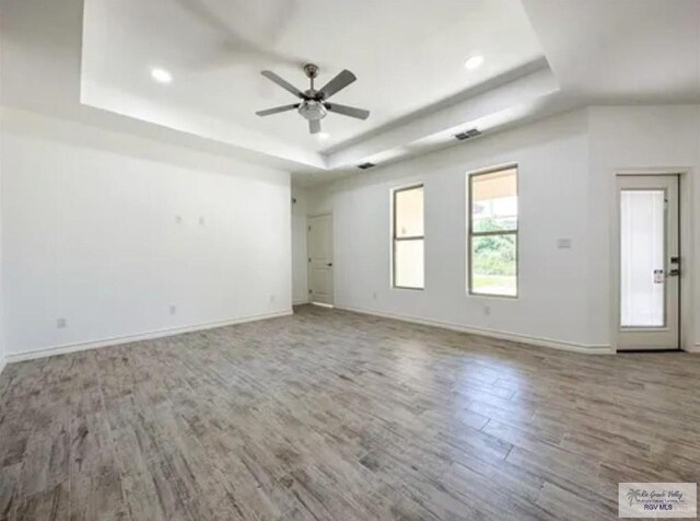 17134 Mandarin Ave, Harlingen, TX 78552 - spare room with a tray ceiling, wood finished floors, ceiling fan, baseboards, and recessed lighting
