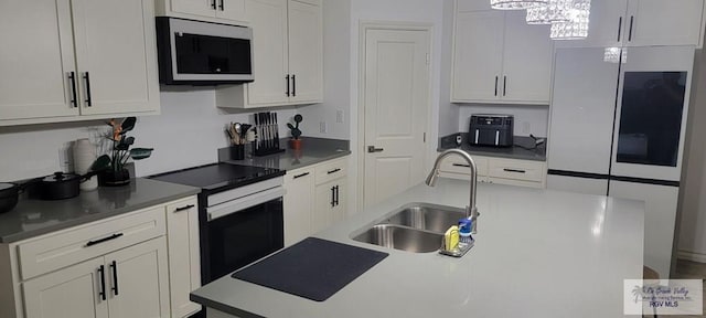 17134 Mandarin Ave, Harlingen, TX 78552 - kitchen featuring stainless steel microwave, a sink, electric range oven, a chandelier, and white cabinets