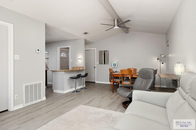 living room featuring light wood-type flooring, vaulted ceiling, and ceiling fan