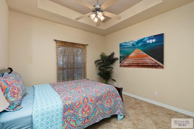 bedroom featuring a raised ceiling and ceiling fan