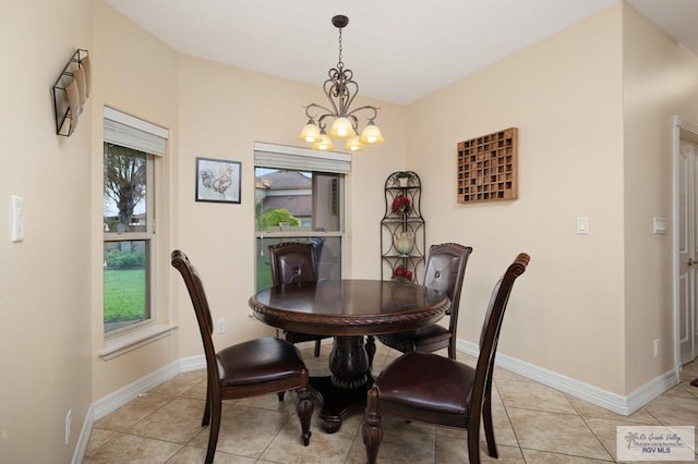 dining space with light tile patterned floors and an inviting chandelier