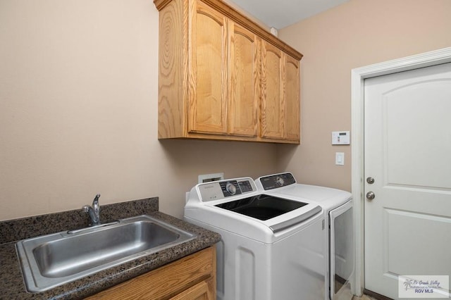 washroom featuring sink, cabinets, and independent washer and dryer