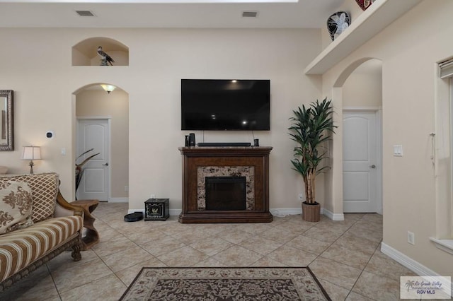 tiled living room featuring a premium fireplace