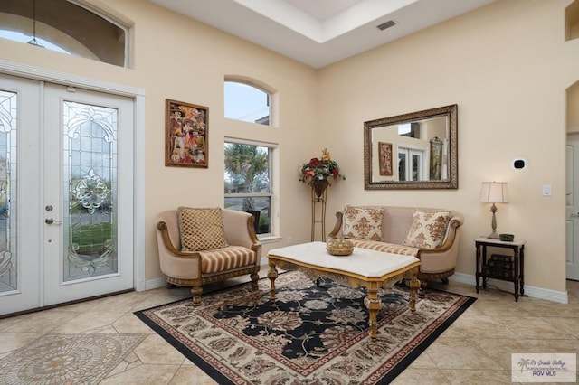 sitting room featuring french doors, a high ceiling, and light tile patterned flooring