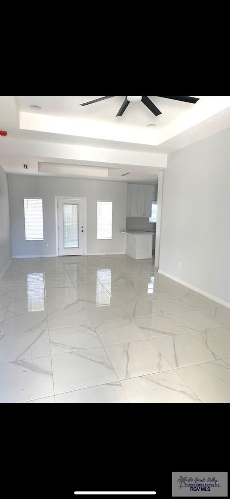 unfurnished room with a tray ceiling and ceiling fan