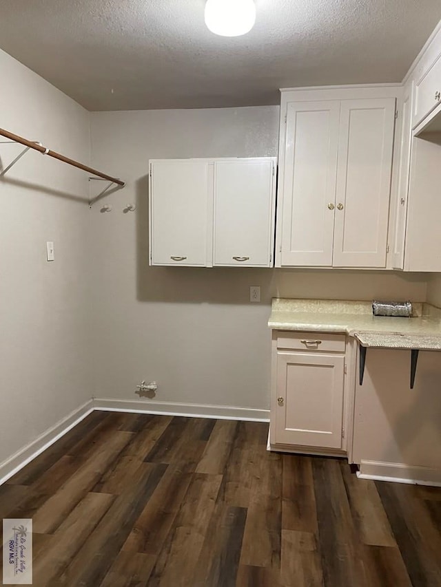 laundry area featuring dark hardwood / wood-style floors and a textured ceiling