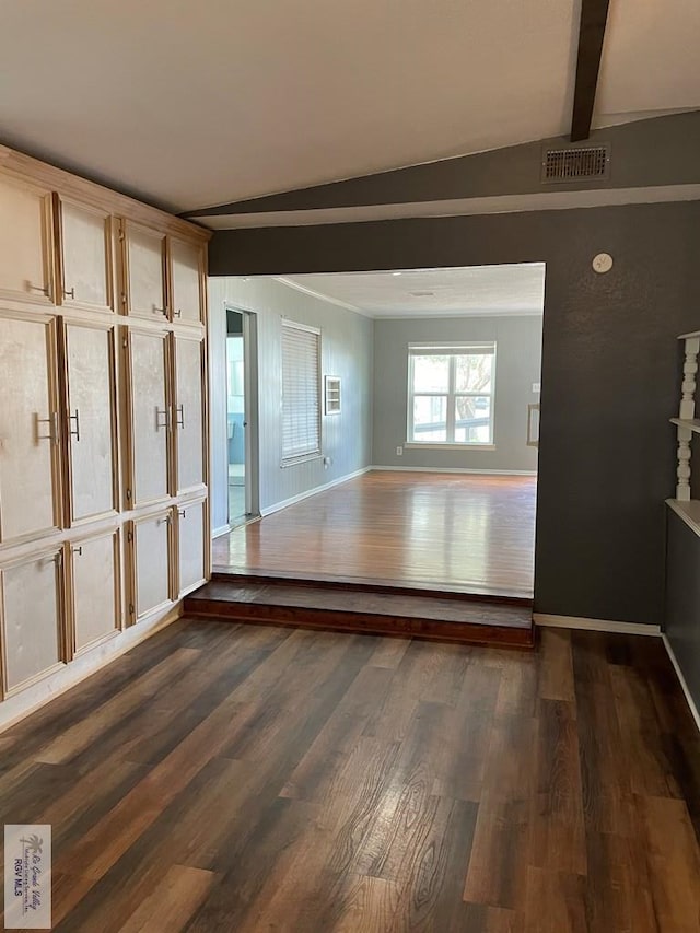 empty room with dark hardwood / wood-style flooring and vaulted ceiling with beams