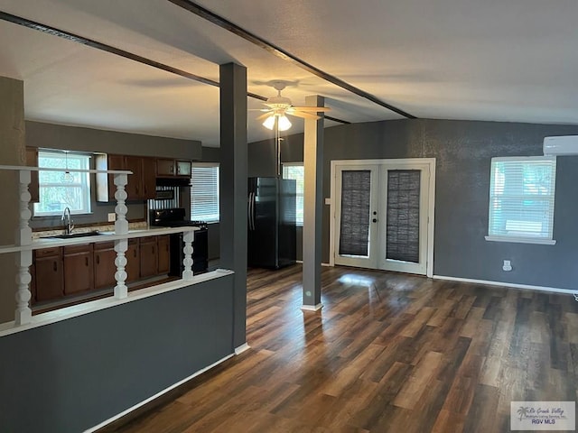 kitchen with french doors, sink, a wall mounted AC, vaulted ceiling, and black appliances