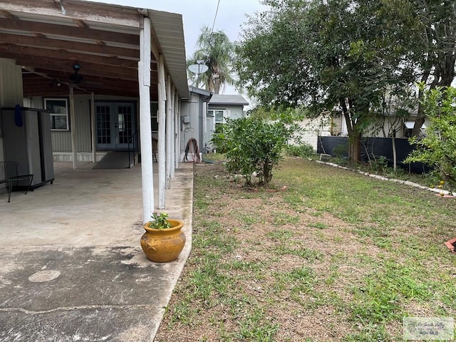 view of yard with french doors, ceiling fan, and a patio