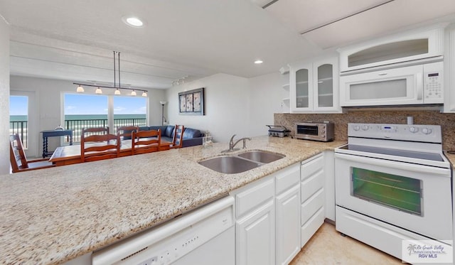 kitchen with white cabinetry, sink, hanging light fixtures, and white appliances