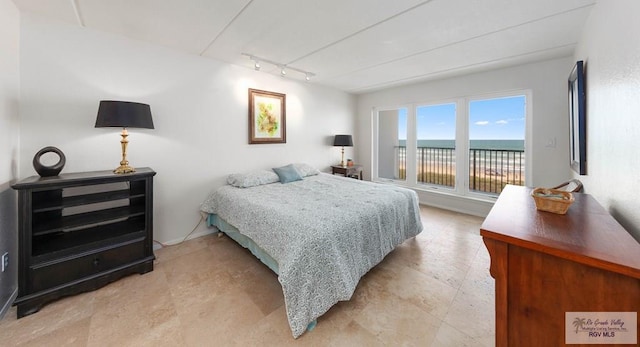 bedroom with a water view and track lighting