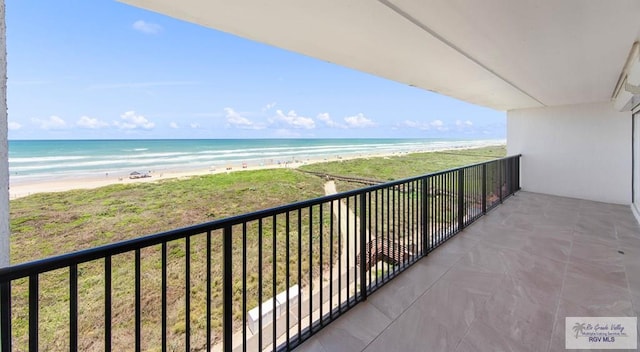 balcony featuring a water view and a beach view