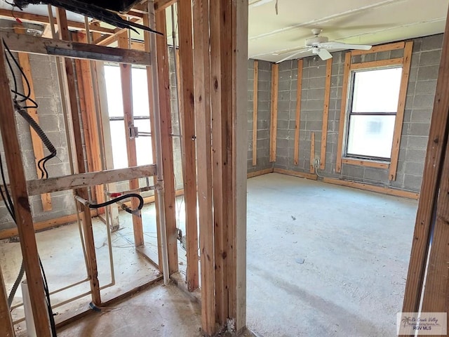 miscellaneous room featuring ceiling fan and unfinished concrete floors
