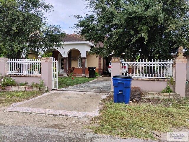 2310 Tiffany Dr, Mission, TX 78574 - obstructed view of property featuring a fenced front yard, stucco siding, a porch, and driveway