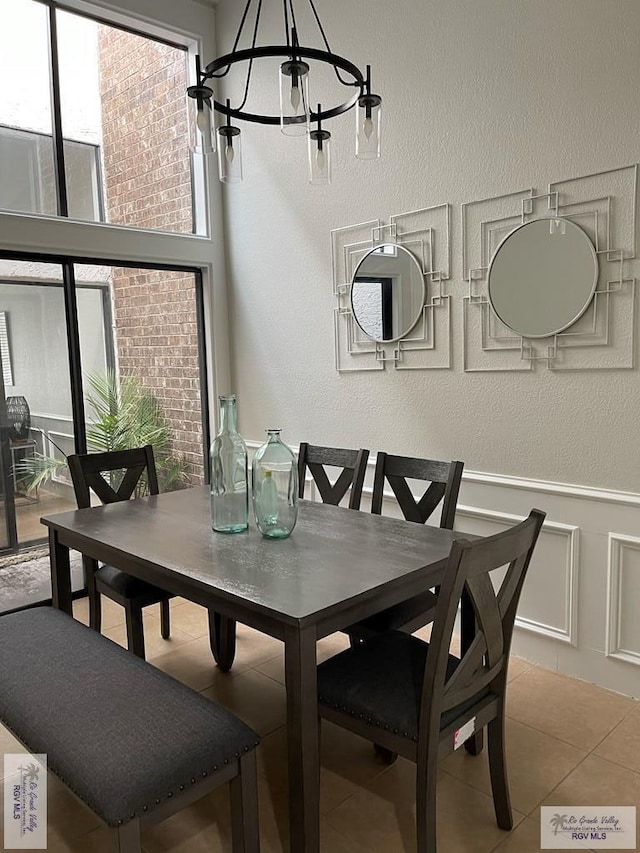 tiled dining area featuring a notable chandelier