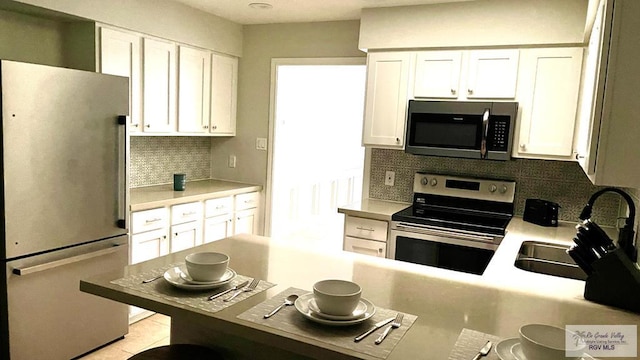 kitchen featuring white cabinetry, appliances with stainless steel finishes, and backsplash