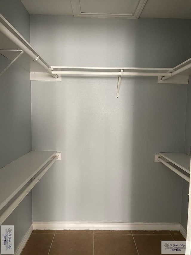 spacious closet featuring dark tile patterned floors