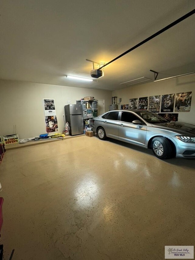 garage with stainless steel fridge and a garage door opener