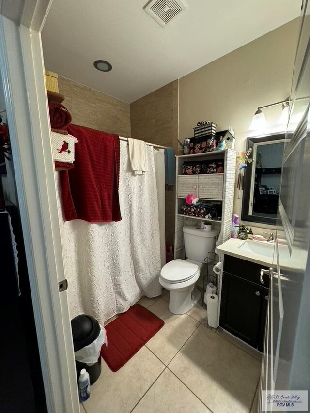 bathroom with tile patterned floors, vanity, curtained shower, and toilet