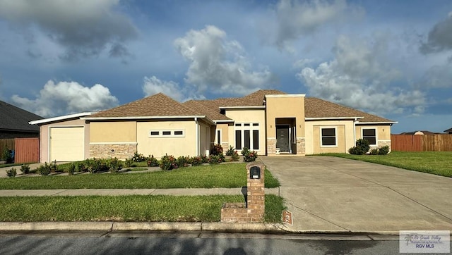 116 Village E Dr, Los Fresnos, TX 78566 - view of front of home with stone siding, stucco siding, concrete driveway, and an attached garage
