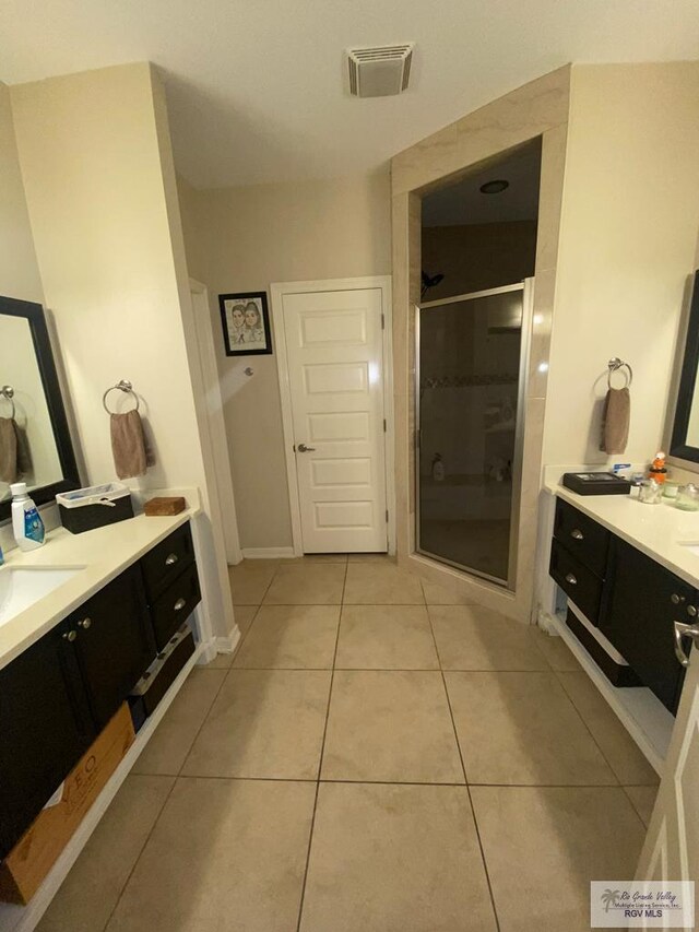 bathroom featuring vanity, tile patterned floors, and a shower with door