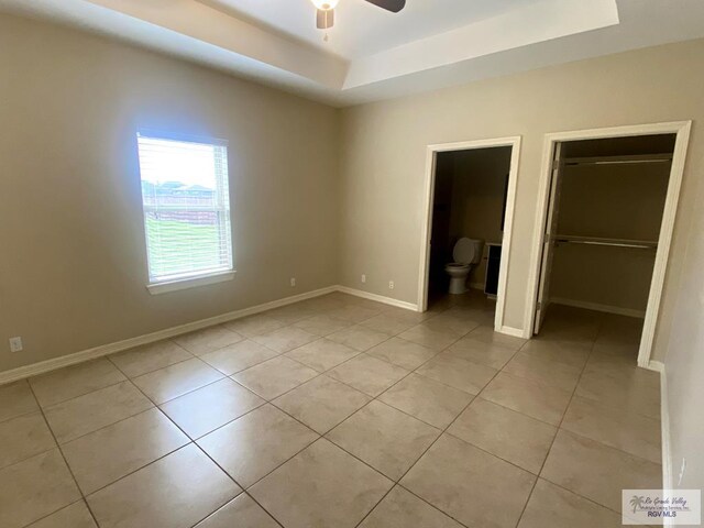 116 Village E Dr, Los Fresnos, TX 78566 - unfurnished bedroom featuring a raised ceiling, light tile patterned floors, baseboards, a closet, and a spacious closet