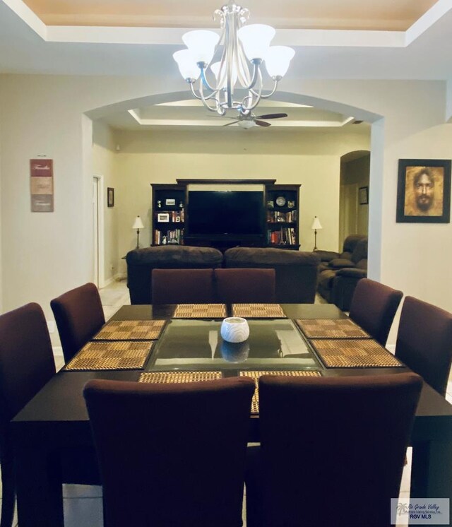 116 Village E Dr, Los Fresnos, TX 78566 - dining area featuring a raised ceiling, arched walkways, and a chandelier