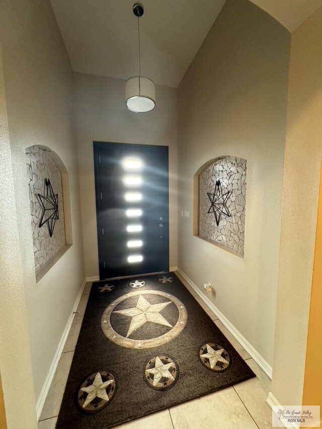 entryway with tile patterned flooring and vaulted ceiling