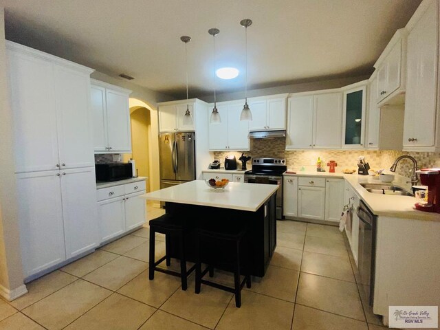 116 Village E Dr, Los Fresnos, TX 78566 - kitchen featuring black appliances, arched walkways, a sink, a kitchen island, and tasteful backsplash