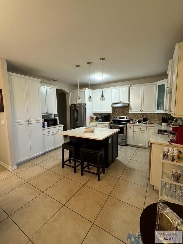 kitchen featuring sink, hanging light fixtures, appliances with stainless steel finishes, tasteful backsplash, and a kitchen island