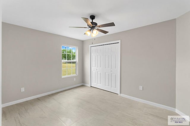 unfurnished bedroom with ceiling fan and a closet