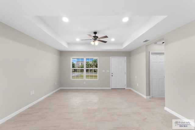 unfurnished room featuring a tray ceiling and ceiling fan