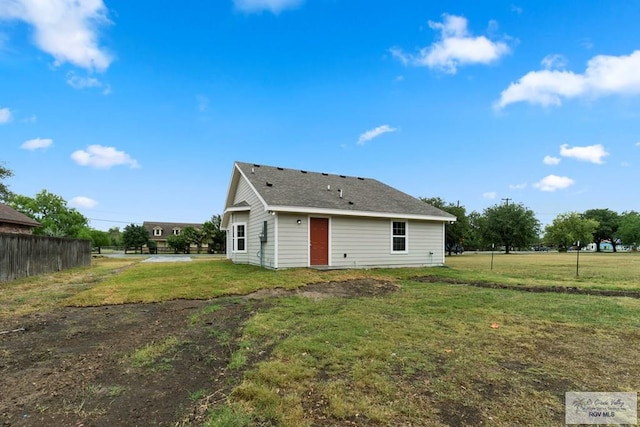 rear view of property featuring a lawn