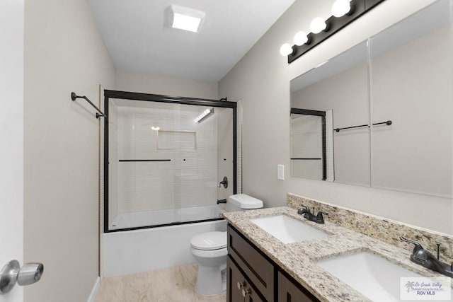 full bathroom featuring vanity, toilet, and combined bath / shower with glass door