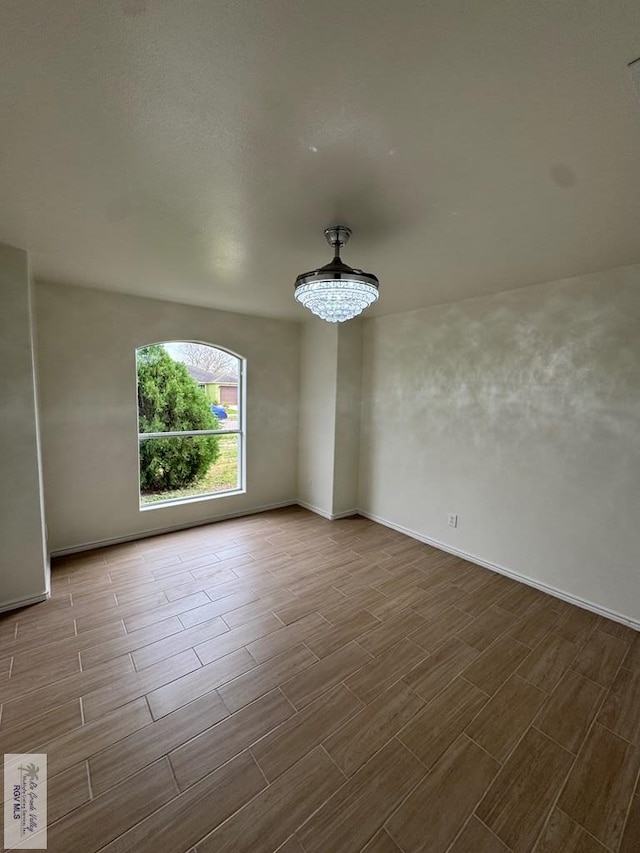 spare room featuring wood finish floors and baseboards