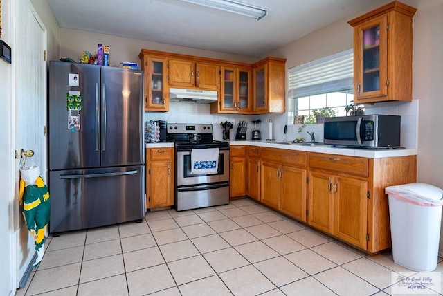 kitchen with light tile patterned flooring, sink, stainless steel appliances, and tasteful backsplash