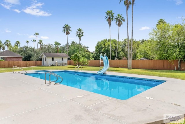 view of pool with an outbuilding, a patio, a lawn, and a water slide