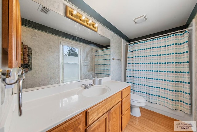 full bathroom with wood-type flooring, vanity, toilet, and shower / bath combination with curtain