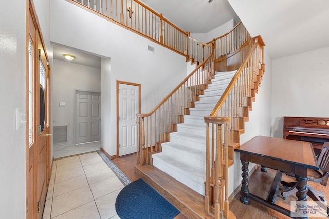 tiled entrance foyer with a towering ceiling