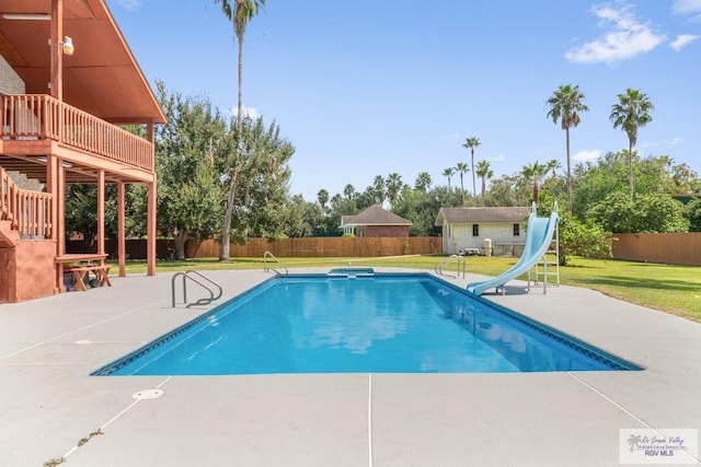 view of pool featuring a lawn, an outdoor structure, a patio, and a water slide