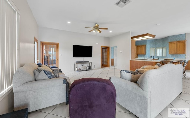 tiled living room featuring ceiling fan and a wealth of natural light