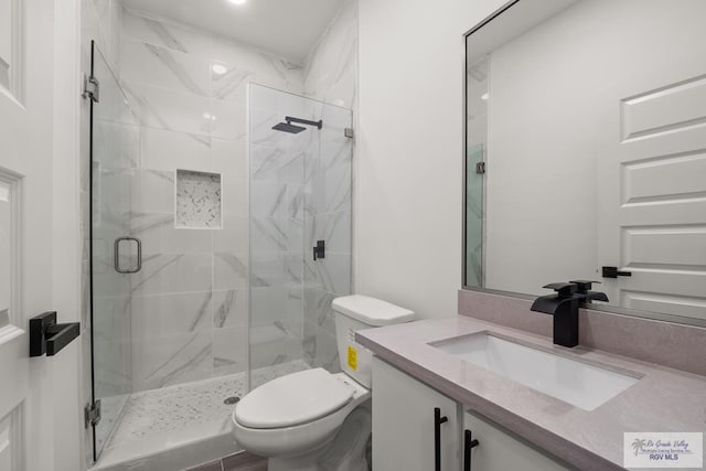 full bathroom with a marble finish shower, toilet, and vanity