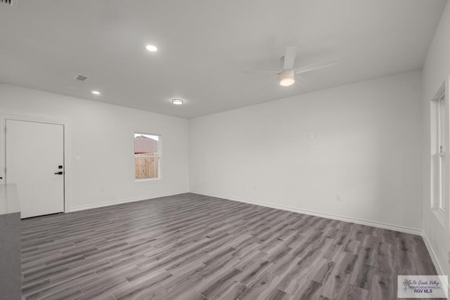 unfurnished room featuring visible vents, baseboards, a ceiling fan, and wood finished floors