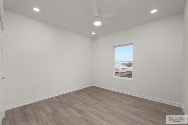 empty room featuring recessed lighting, wood finished floors, and baseboards