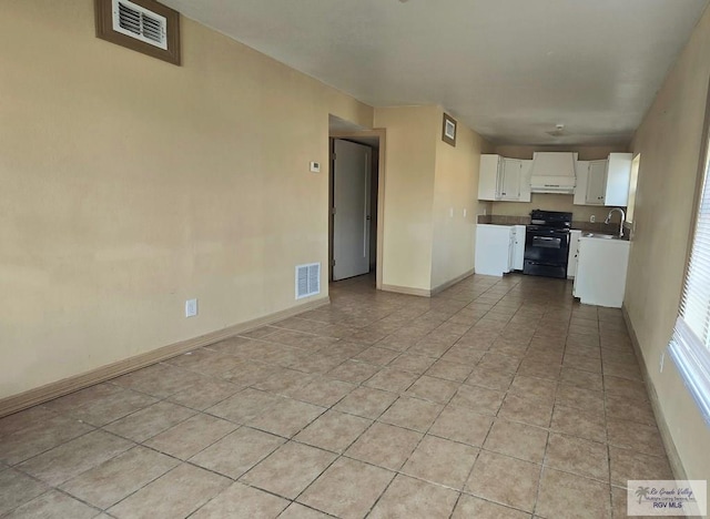 kitchen featuring white cabinets, light tile patterned floors, sink, and black / electric stove