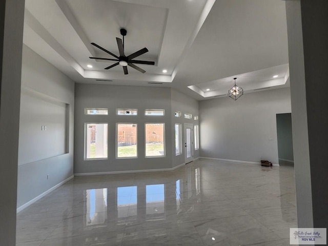 unfurnished room with recessed lighting, ceiling fan with notable chandelier, baseboards, marble finish floor, and a raised ceiling