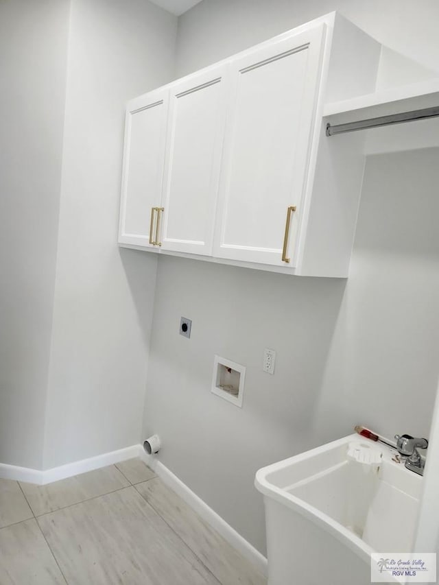 washroom featuring cabinet space, baseboards, hookup for an electric dryer, washer hookup, and a sink