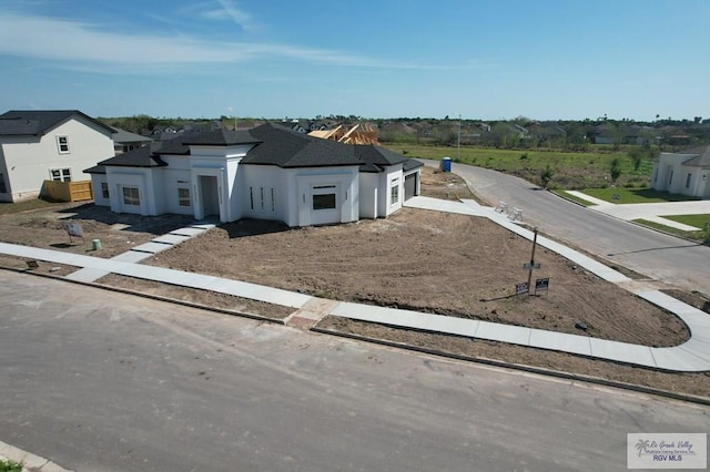 view of front of home with a garage, a residential view, and fence