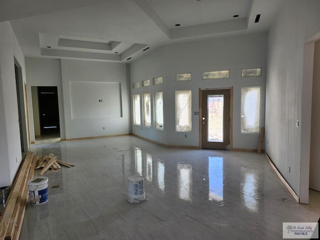 interior space featuring a raised ceiling and a high ceiling